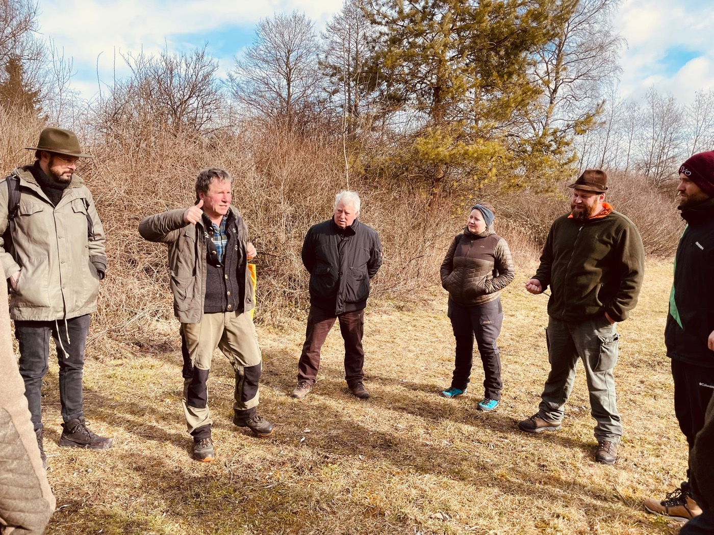 Gruppe Jagdschueler im Gespraech mit Ausbilder auf Wiese Praxisunterricht Revierkunde der Jagdausbildung